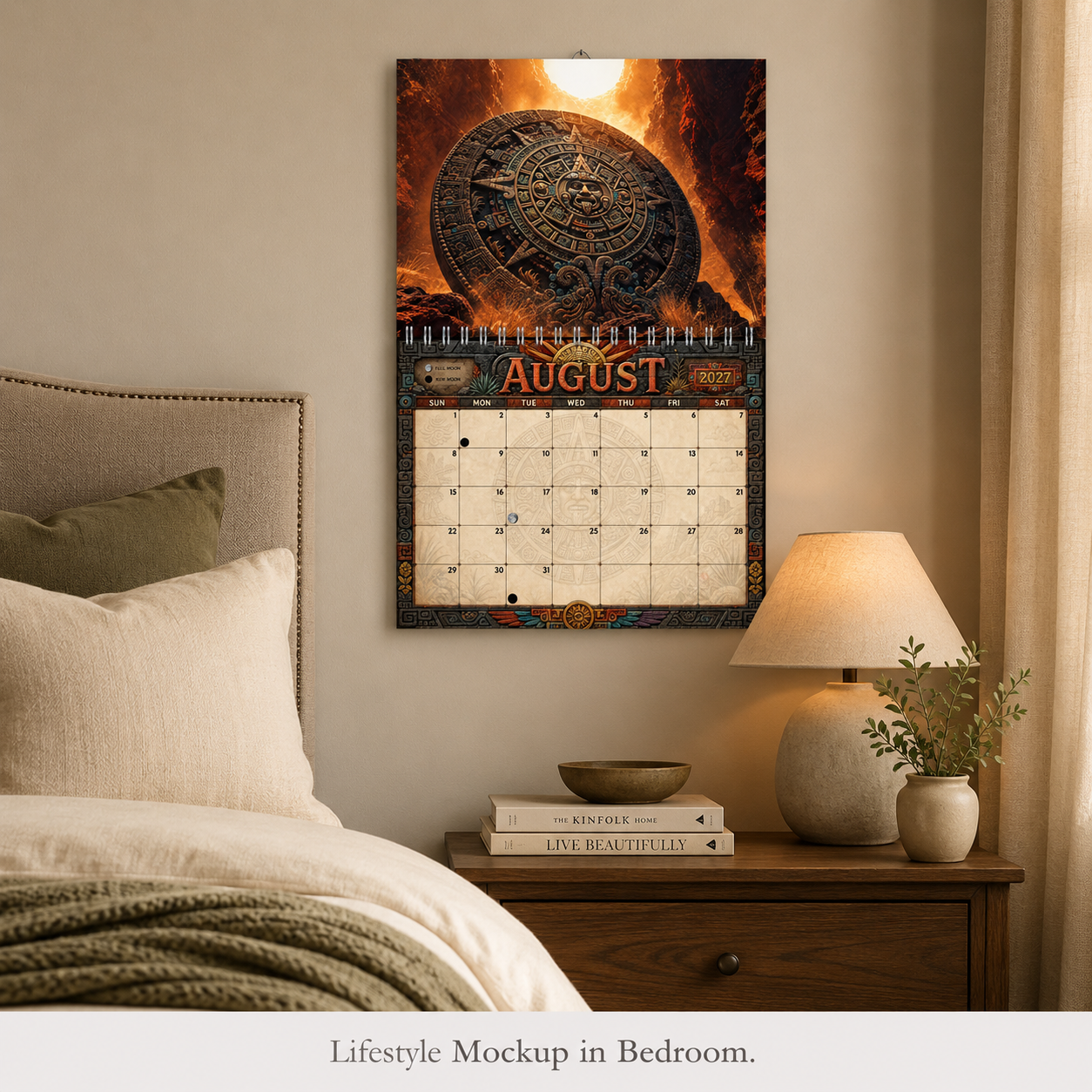 Aztec Sun Stone 2027 wall calendar displayed on a bedroom wall beside a nightstand and lamp, August volcanic canyon page shown