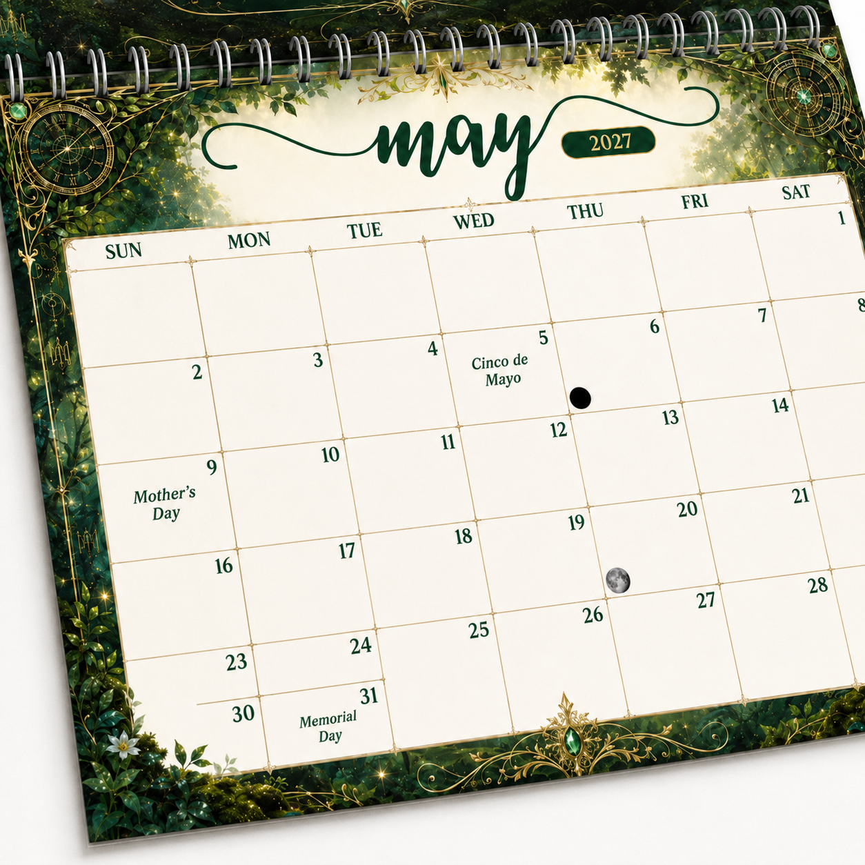 Close-up of the May 2027 date grid in the Guardians of Time wall calendar, framed in green ivy and gold, showing U.S. holidays and moon phases